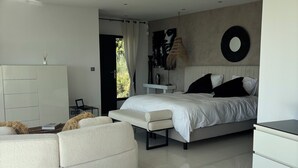 Un dormitorio moderno con cama, mesita de noche y un amplio ventanal.