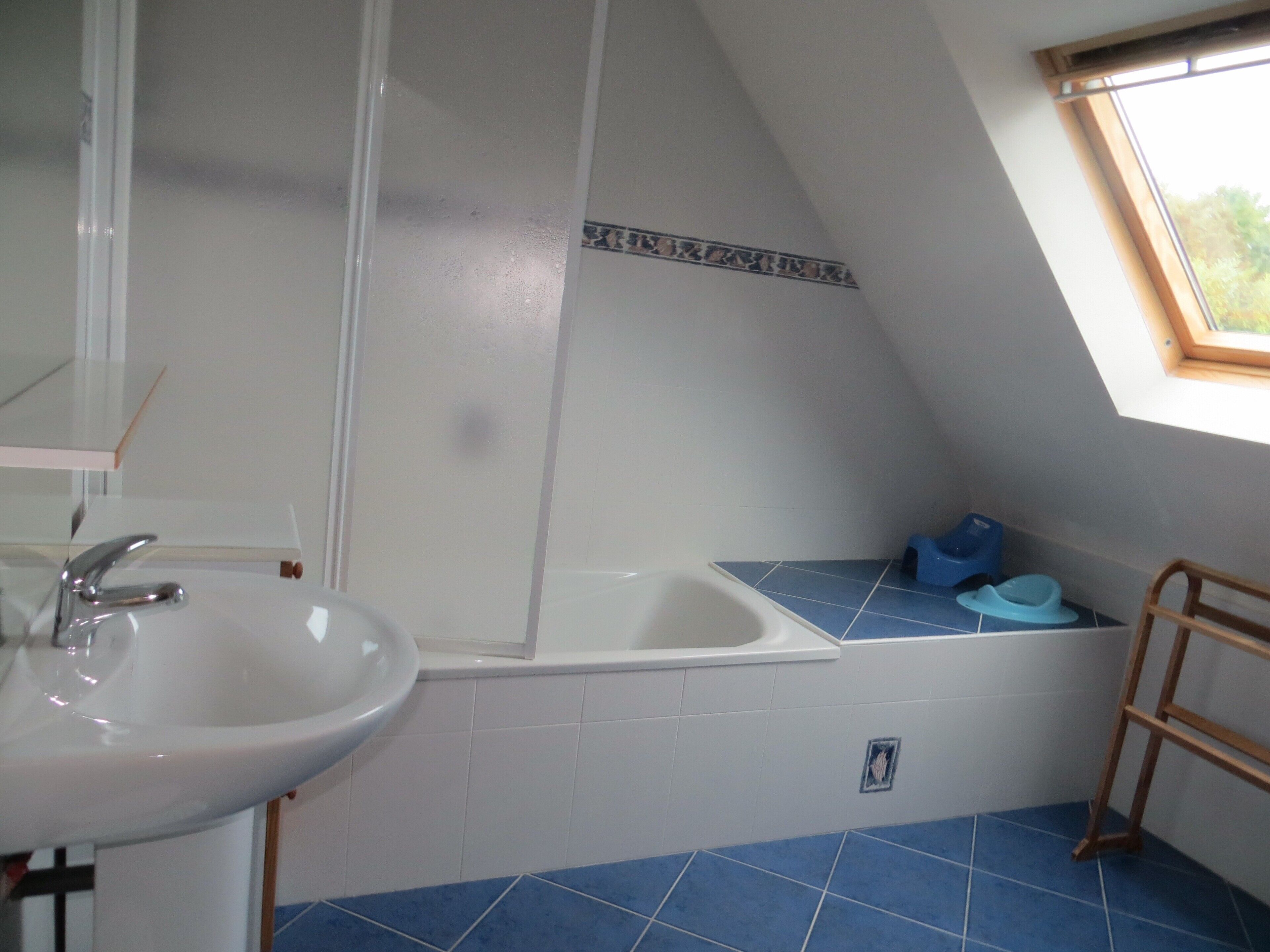 Une salle de bain avec un lavabo, une baignoire et une fenêtre.