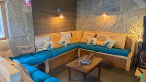 Ein gemütlicher Wohnbereich mit einer hölzernen Bank, einem blauen Sofa und einem Couchtisch.