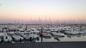 A marina filled with various boats docked at wooden piers.