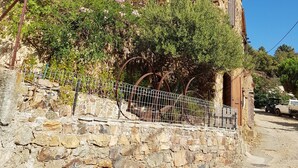 A stone building with a rustic appearance, featuring a stone wall and a metal fence. - Traditional house, spectacular view of the Gulf of Porto (Partinello)