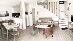 Ein modernes Interieur mit Essbereich, Sofa, Fernseher und Treppe.