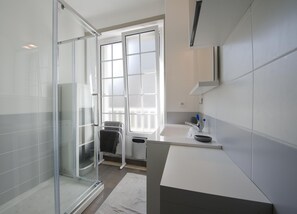 Regadera, secadora de cabello, toallas, papel de baño 