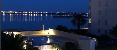 Hotel med swimmingpool, udsigt til en bro og en godt oplyst indgang.