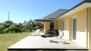 A patio with outdoor seating, a table, and a covered area. - Single storey house, enclosed land 400 m from the beach of pors-Carn (Penmarch)