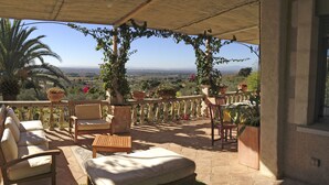 A covered outdoor seating area with a view of the landscape.