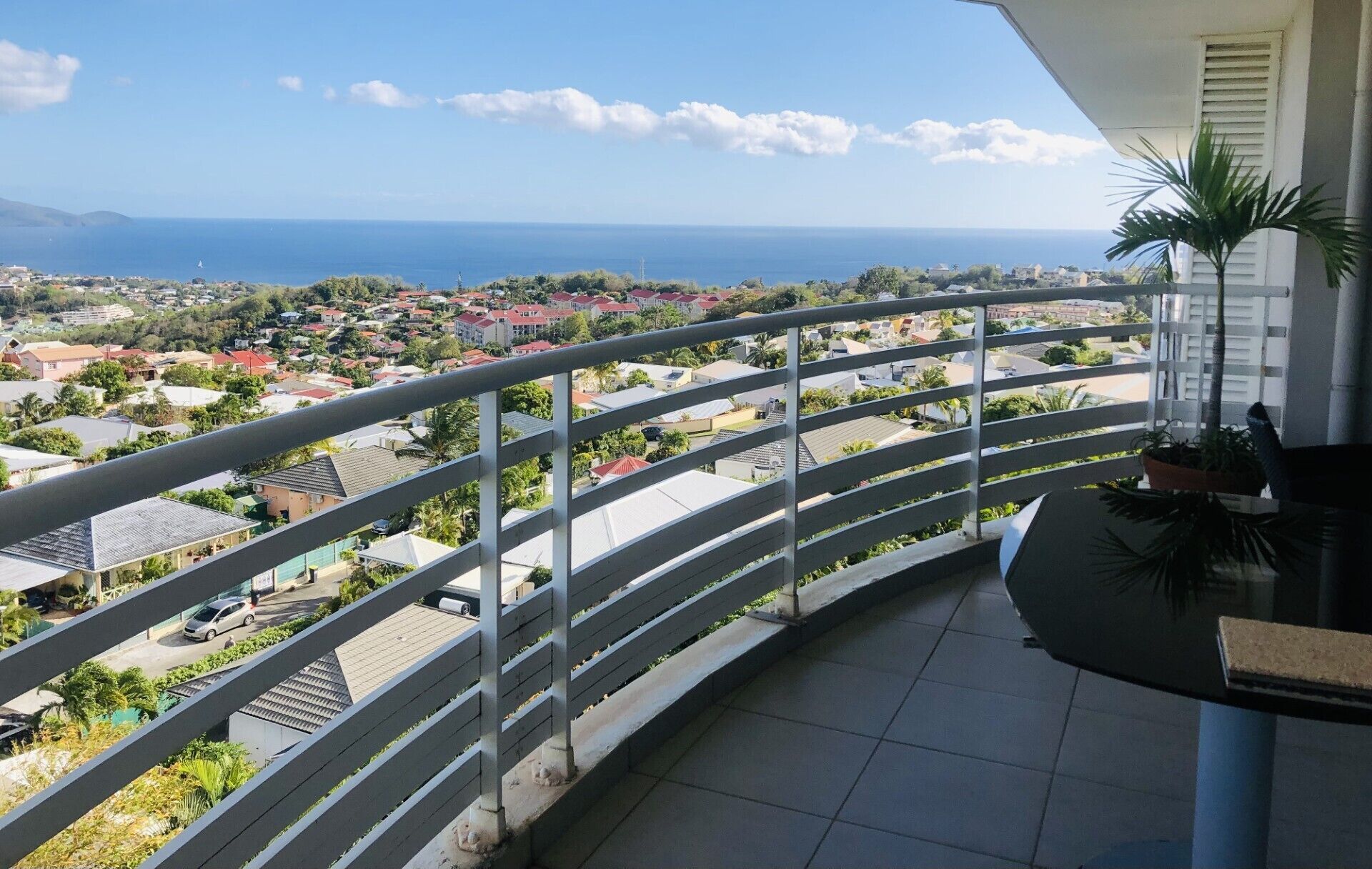 Ein Balkon mit Blick auf eine Küstenstadt und das Meer.