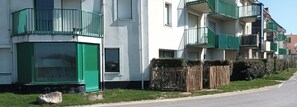 Ein Wohngebäude mit Balkonen, einem verschlossenen Eingang und einer klaren Straße daneben.