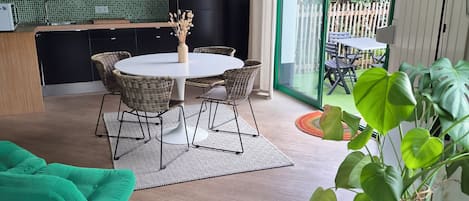 A modern interior with a dining area, kitchen, and a view of the outside.