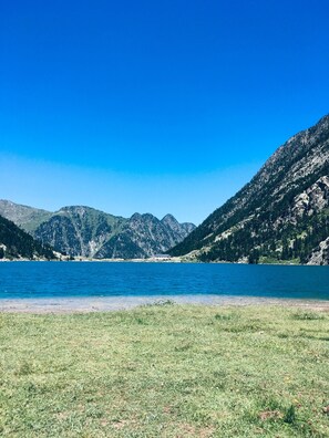Un lac entouré de montagnes, sous un ciel dégagé.