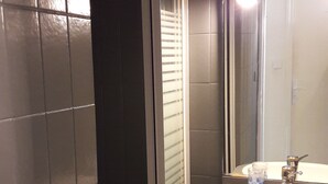 A bathroom with a toilet, sink, and mirror.