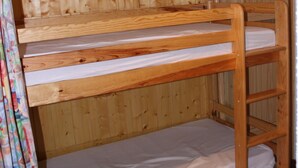 A bunk bed with a wooden headboard and a lower bunk with a mattress. - SPACIOUS STUDIO 30M2 balcony south facing terrace 4 pers near downtown (Barcelonnette)