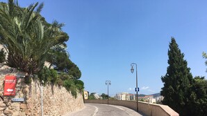Ruas de paraleipípedos com uma parede de pedra e uma placa vermelha indicando o Musée de la Castre.