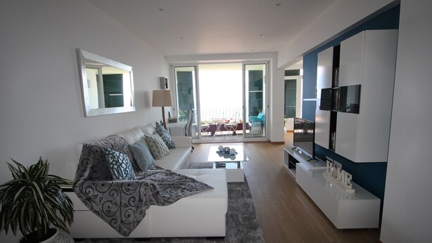 A modern living room with a white sofa, a coffee table, and a TV stand. - Fully renovated apartment, in the Centre of Funchal. AMAZING view (Funchal)