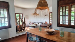 Un espace repas comprenant une table en bois, des chaises et un luminaire suspendu.