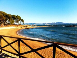 A beach with a wooden fence, sandy shore, and a clear view of the sea and distant mountains. - House with superb  pool and big garden, wifi, parking in L'Escala, 7 people (L'Escala)