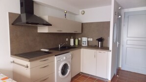 A compact kitchen with a washing machine, a coffee maker, and a sink. - Maset conditioning in a closed condominium with guardian. (Le Lavandou)