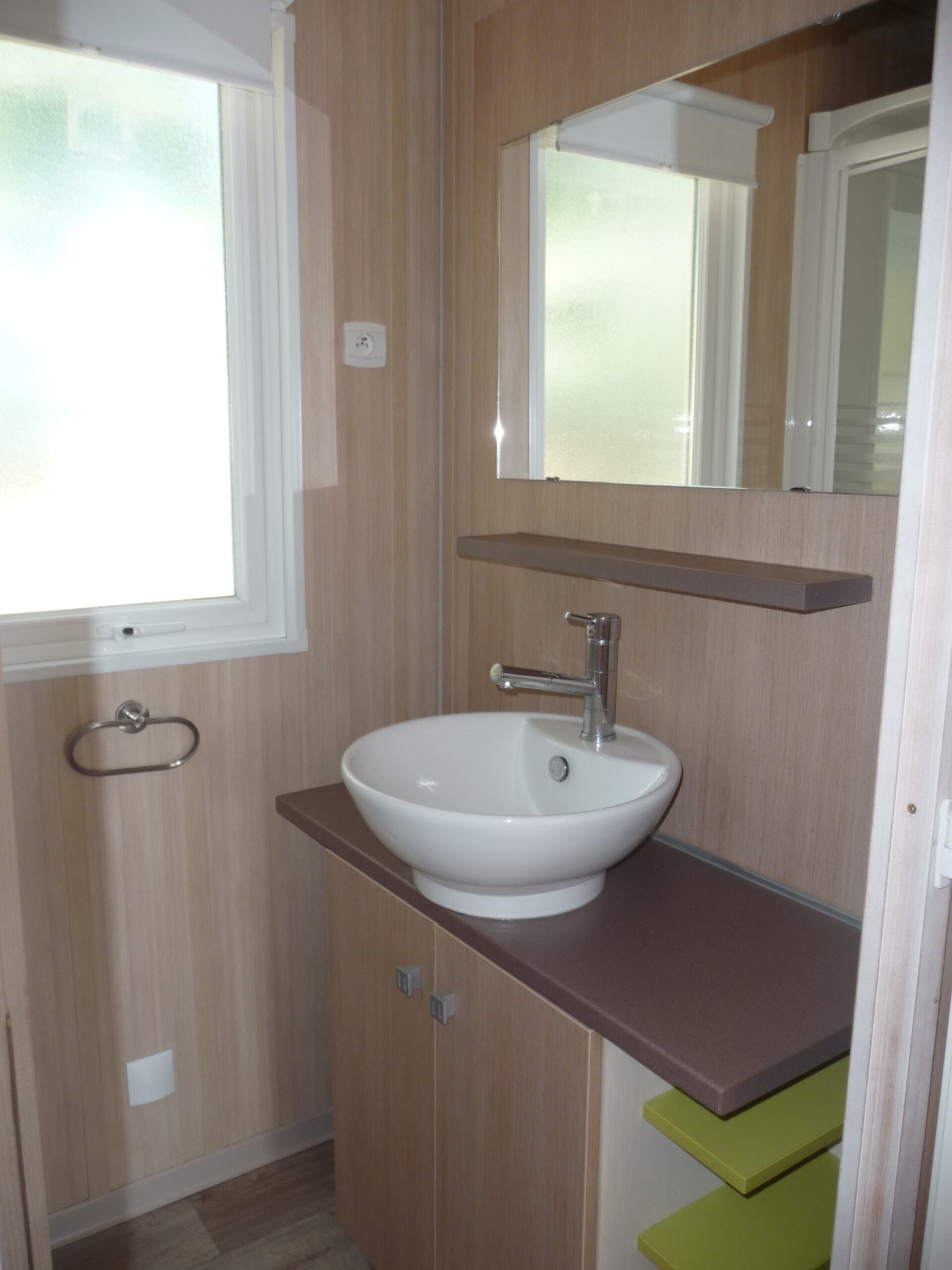 A compact bathroom with a sink, mirror, and a window.