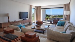 A modern hotel room with a large flat-screen TV, a sofa, a coffee table, and a view of the ocean. - Luxurious villa with sea views in Essaouira (Essaouira)