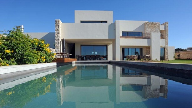 A modern house with a swimming pool, stone accents, and a patio with outdoor furniture. - Luxurious villa with sea views in Essaouira (Essaouira)