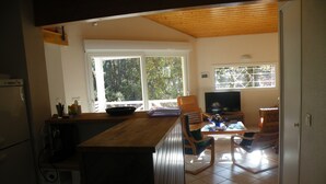 Una cucina con piano di lavoro in legno, frigorifero e zona pranzo con tavolo e sedie.