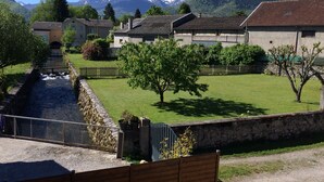 Un quartier résidentiel avec des maisons, un petit ruisseau et des montagnes en arrière-plan.