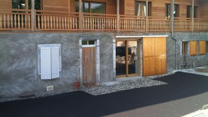 Un bâtiment à deux étages doté d’un balcon, de portes en bois et d’une façade en pierre.