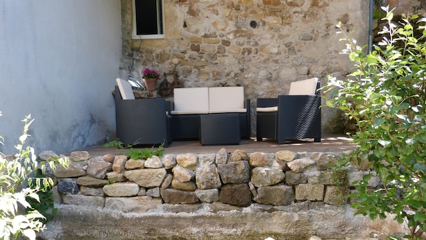 A stone staircase leading to a seating area with wicker furniture.