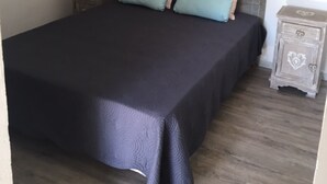 A bedroom with a bed, two bedside tables, a hanging lamp, and a wall with the word "ENJOY". - Gloria's house ...   (Saint-Rémy-De-Provence)