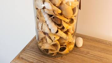 Ein Glasgefäß, gefüllt mit getrockneten Pilzen auf einer Holztischfläche.