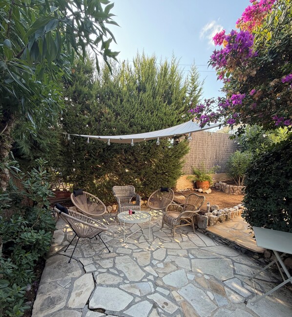 A patio with stone flooring, wicker furniture, and a canopy.