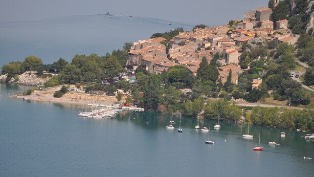 A coastal town with buildings on a hillside overlooking a calm sea. - With view on the lake of Ste Croix, contemporary villa for 8 people  (Bauduen)