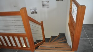 A wooden staircase with a handrail and a metal safety rail, leading to a room with a white wall and a door. - With view on the lake of Ste Croix, contemporary villa for 8 people  (Bauduen)