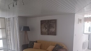 Un salon avec un canapé, une table basse, une lampe et un tableau au mur.