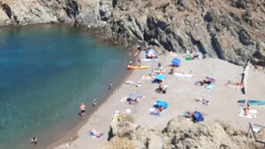 A beach with clear water, rocky cliffs, and people sunbathing. - Renovated villa with exceptional panoramic view (Banyuls-Sur-Mer)