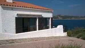 A white building with a red-tiled roof, large windows, and a view of the sea. - Renovated villa with exceptional panoramic view (Banyuls-Sur-Mer)