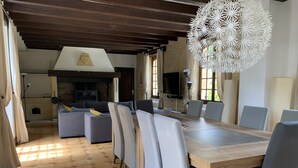 Un coin repas avec une table et des chaises en bois, un canapé et une cheminée.