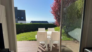 A room with a sliding glass door leading to an outdoor deck with a table and chairs. - Beautiful view of the port and the Verdelet. Garden level. Wifi   (Erquy)