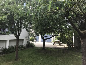 A grassy area with trees and a picnic table.