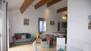 A living room with a grey sofa, a glass coffee table, and a dining area with a white table and chairs. - Superb new T3 apartment in the heart of Sanary, 100m from the port, 2 minutes on foot,  (Sanary-Sur-Mer)