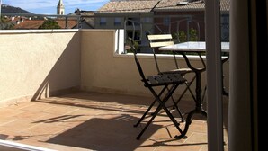 A balcony with a table and chairs, a view of buildings, and a clear sky. - Superb new T3 apartment in the heart of Sanary, 100m from the port, 2 minutes on foot,  (Sanary-Sur-Mer)