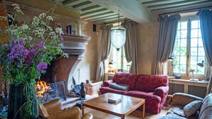 Una sala de estar acogedora con chimenea, un sofá rojo y una mesa de centro de madera.