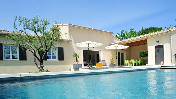 Une piscine avec un patio couvert, un espace salon extérieur et un arbre.