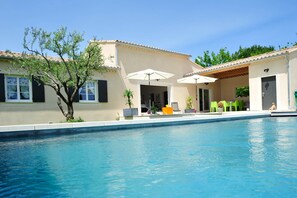 A swimming pool with a covered patio area, outdoor seating, and a tree. - Brand new house, with all comfort and pool, at the foot of the Mont Ventoux. (Vaison-La-Romaine)