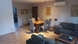 Una sala de estar con un sofá, una mesa de centro y una mesa de comedor con sillas.