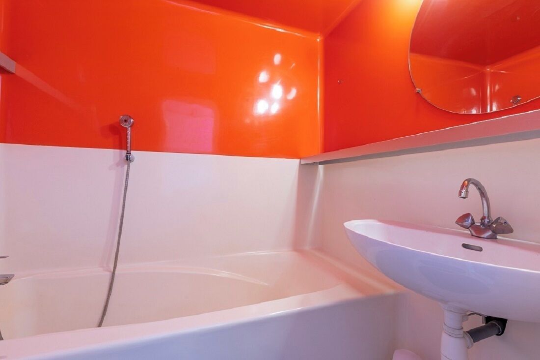Ein Badezimmer mit einer weißen Badewanne, einem weißen Waschbecken und einem Spiegel darüber.