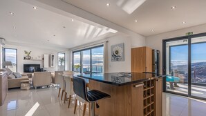 Una cocina moderna con barra, ventanas amplias y vistas a la ciudad.