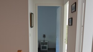 A narrow hallway with a wooden handrail on the left, leading to a room with a bed and a nightstand. - Quimiac Villa by the sea, close to all shops (Mesquer)