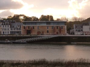 A riverside view with a bridge, buildings, and a calm water body.