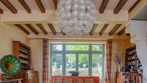 A cozy living room with a wooden ceiling, a round coffee table, and orange armchairs. - Family home in a wooded park with swimming pool near Futuroscope (Thurageau)